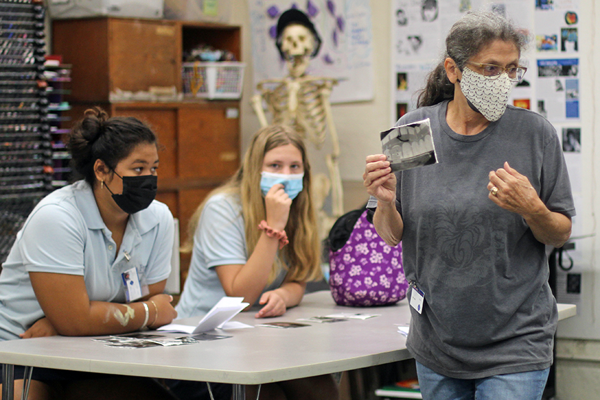 Mary Belanger talks to students about their newly developed photos.