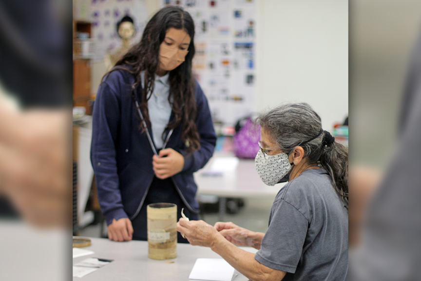Leilani S. works with Mary Belanger to prep her pinhole camera.