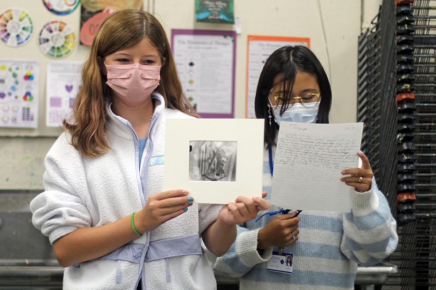 7th grader Mai A. (right) reads the story she wrote about her photograph. 
