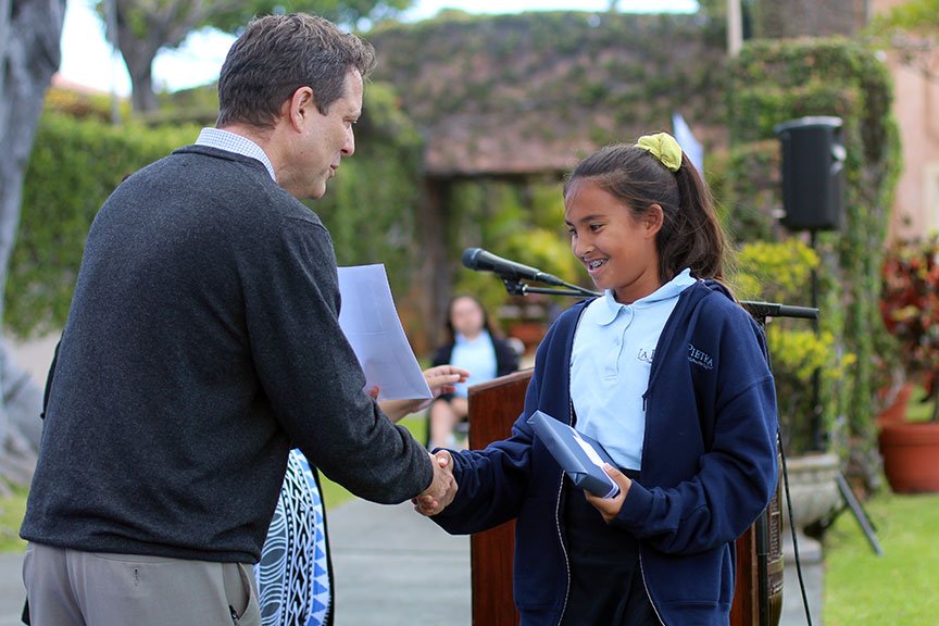 Dr. Watson hands Mia D. her Middle School Award for Grade 7